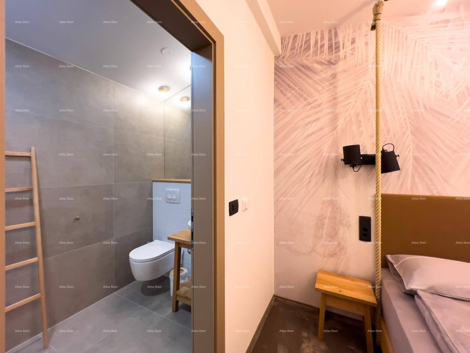 Blick vom Schlafzimmer ins Badezimmer mit Toilette und modernen grauen Fliesen, die einheitlich wirken.