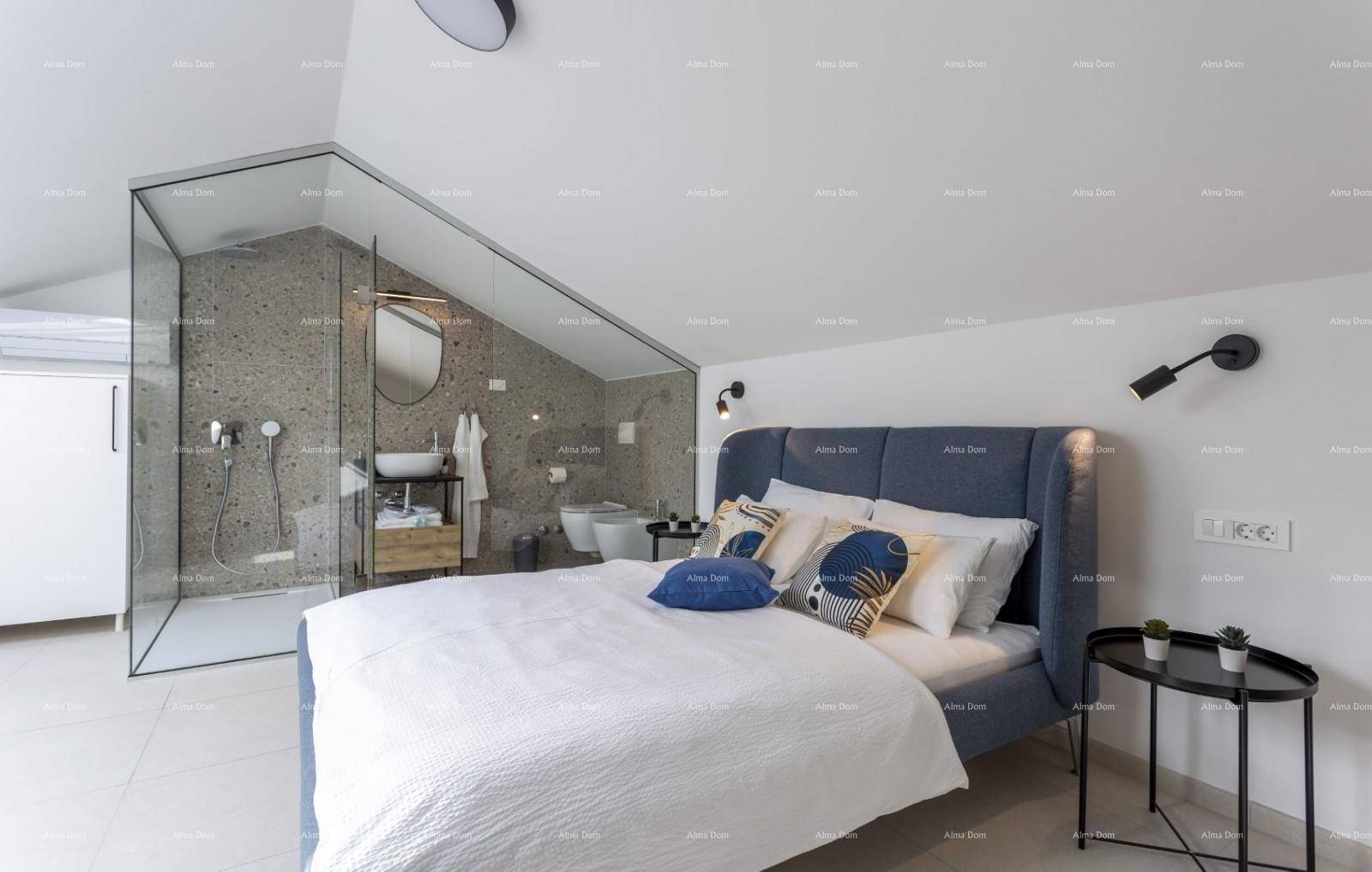 Schlafzimmer mit offenem Badbereich, begehbarer Dusche und charakteristischer Dachschräge.
