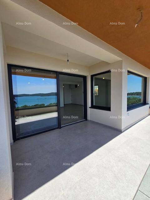 Überdachter Balkon mit Fliesenboden und Zugang zum Innenbereich, bietet Schutz und Meerblick.