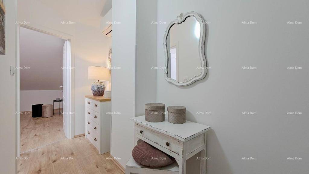Heller Flur mit dekorativem Spiegel, Kommode und Blick in ein Schlafzimmer.