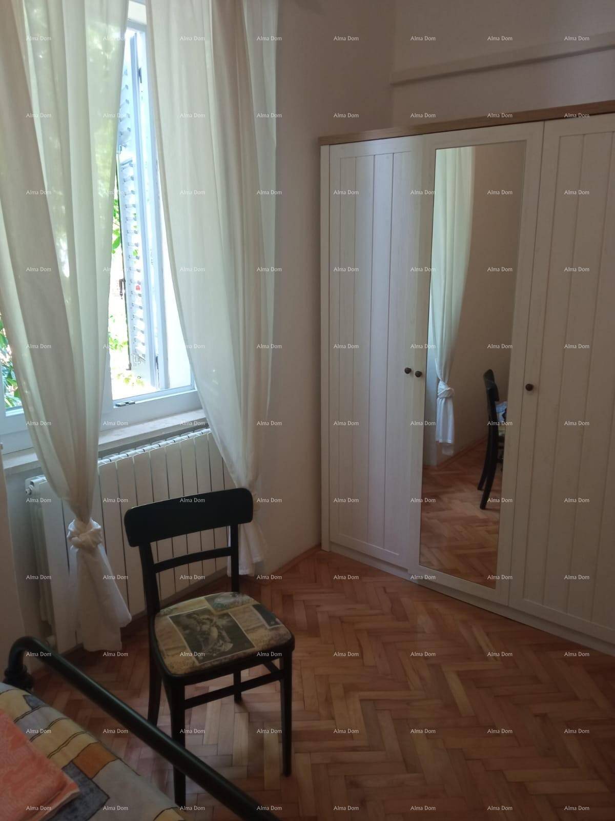 Helles Schlafzimmer mit Parkettboden, Spiegelschrank und Fenster mit Vorhängen für angenehmes Licht.