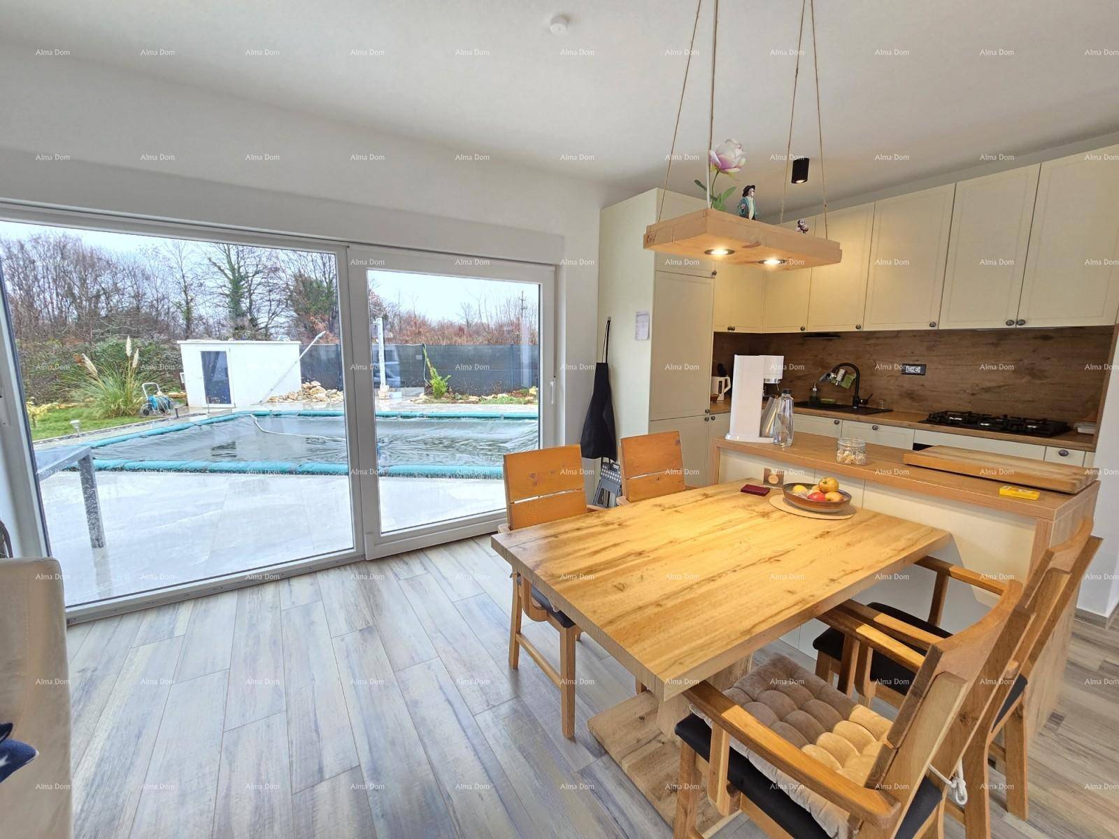 Essbereich mit großem Holztisch und direktem Zugang zur Terrasse mit Poolblick.