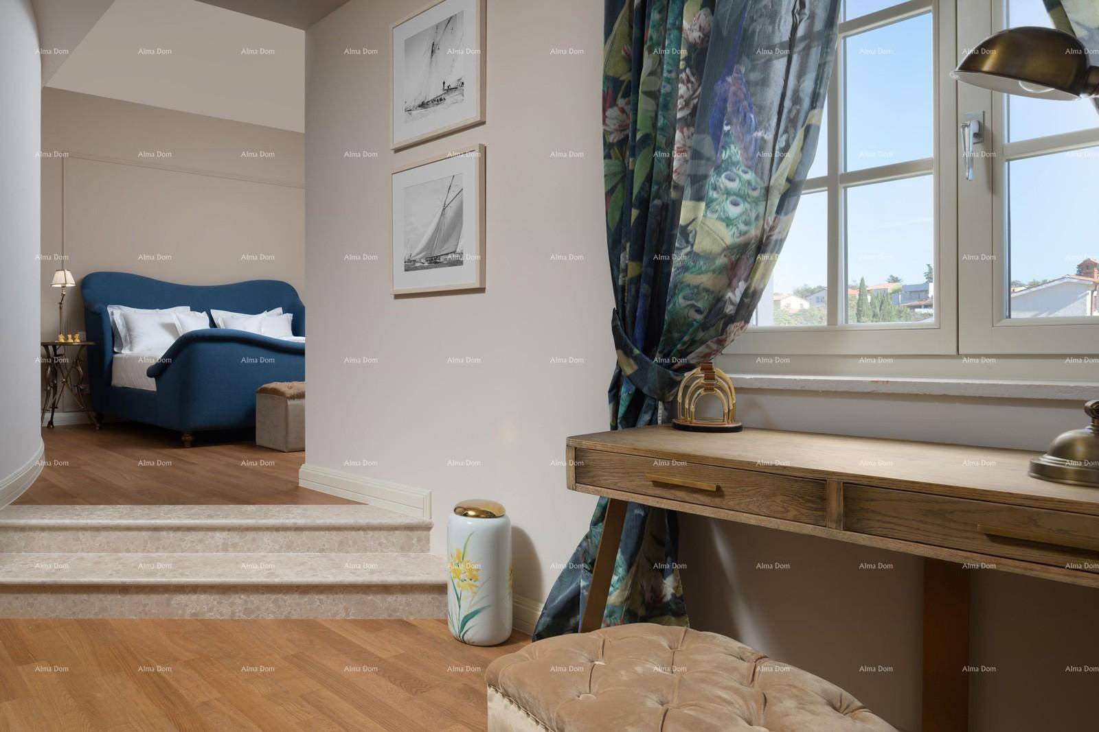 Schlafzimmer mit Holzboden, Schreibtisch und Blick durch das Fenster ins Grüne.