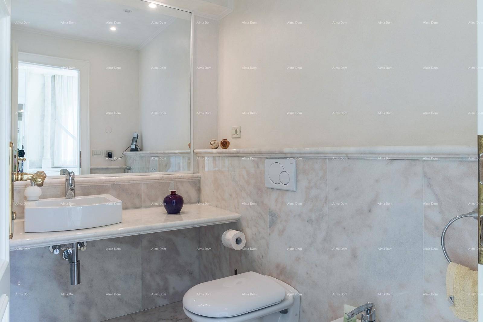 Modernes Gäste-WC mit Marmorwänden, wandmontierter Toilette und elegantem Waschbecken.