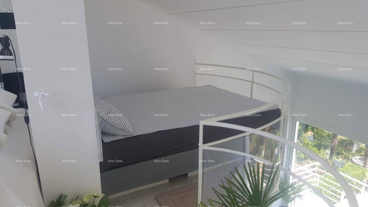 Gemütlicher Schlafbereich im Loft-Stil mit einem Bett auf einer erhöhten Ebene und Blick nach draußen.