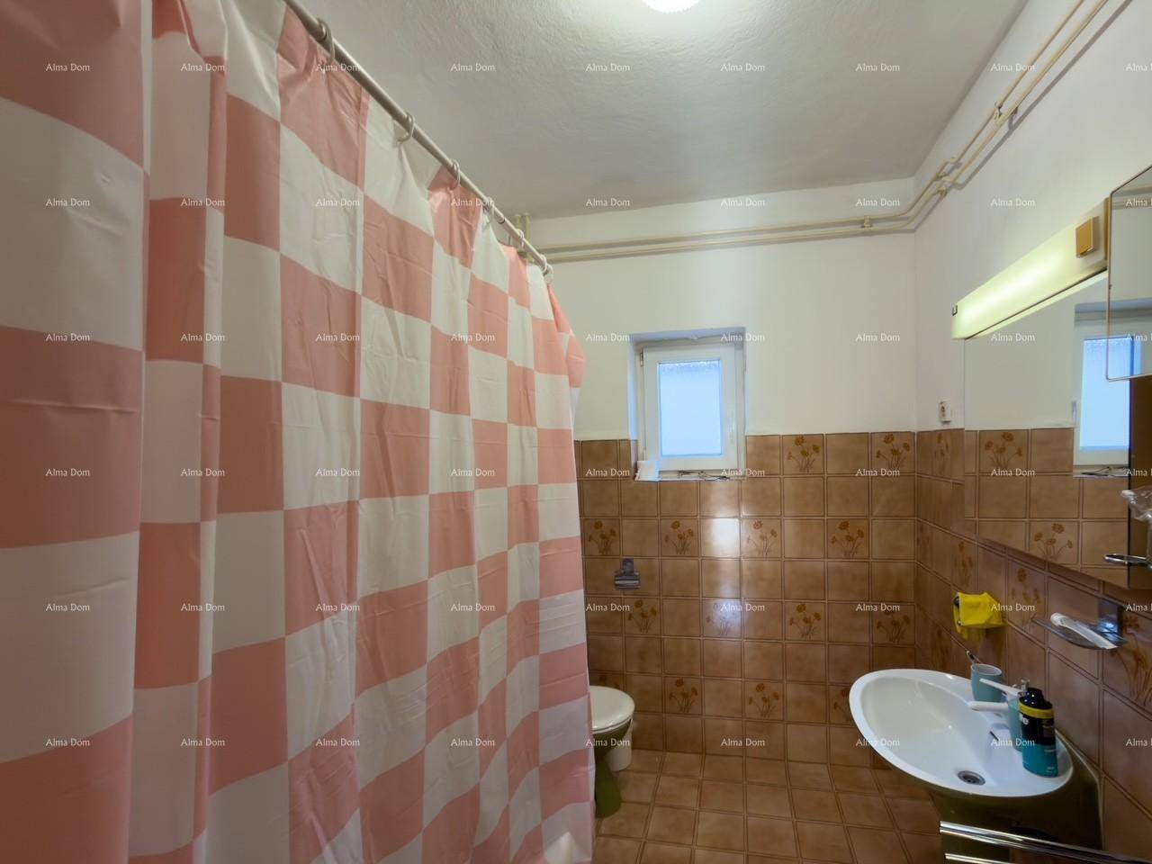 Badezimmer mit Dusche, WC, Waschbecken und braunen Fliesen.