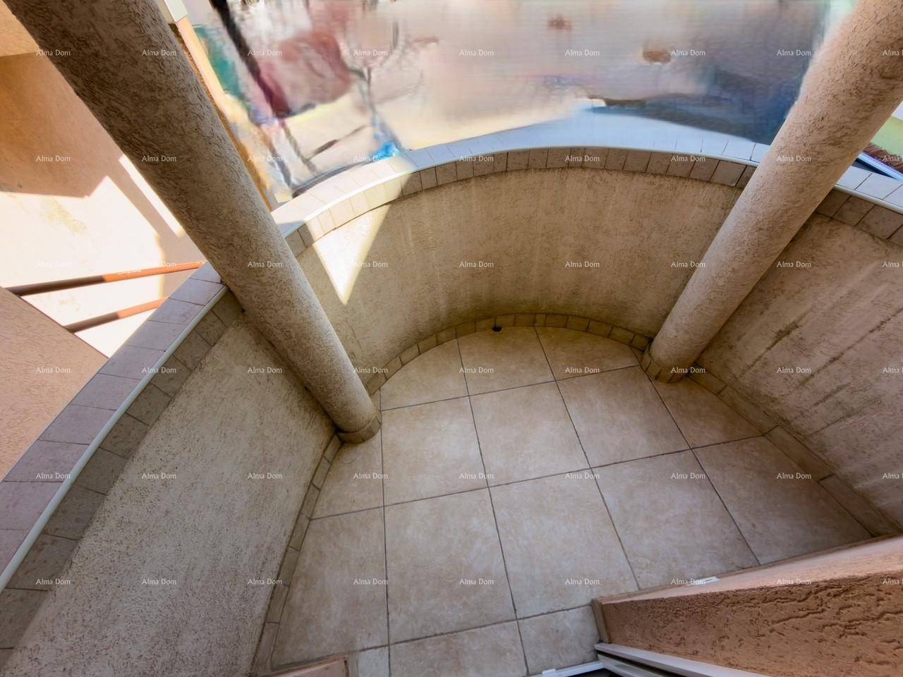 Gebogener Balkon mit Fliesenboden und strukturierten Wänden.
