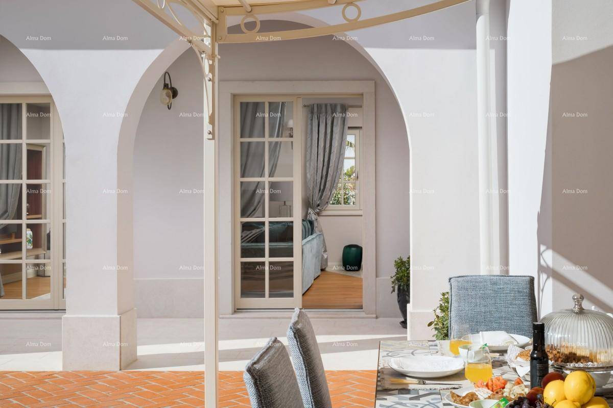 Überdachte Terrasse mit Esstisch und Blick durch französische Türen in einen Innenraum.