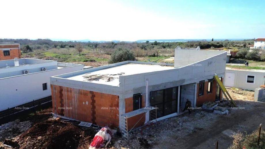 Baustelle einer modernen Villa mit Ziegelwänden und Flachdach in ländlicher Umgebung.