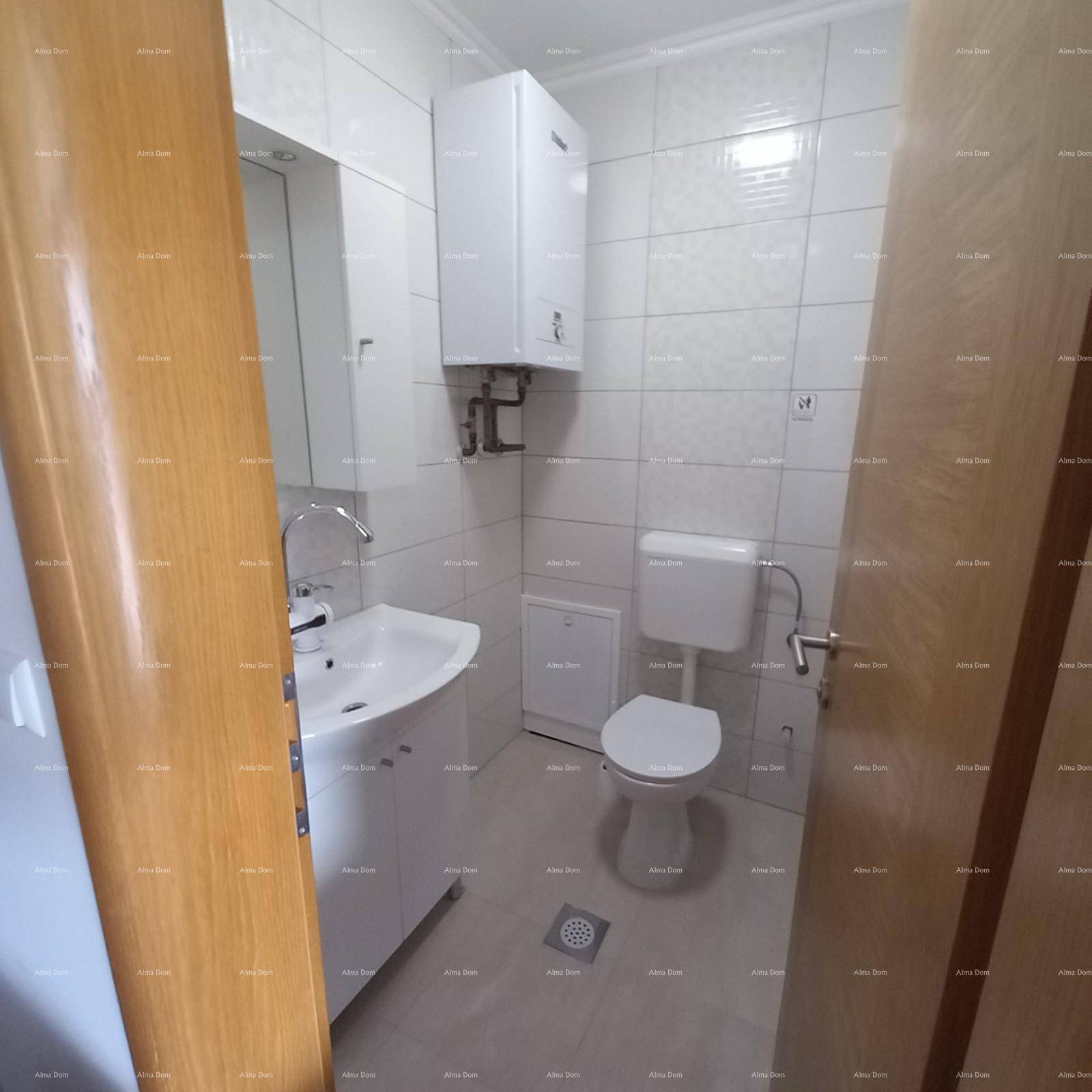 Kleines Badezimmer mit weißen Fliesen, Toilette, Waschbecken und Warmwasserbereiter, funktional eingerichtet.