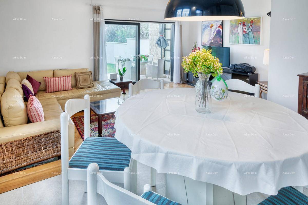Gemütlicher Wohnbereich mit Esstisch, Sofa und Blick auf die Terrasse durch große Glastüren.