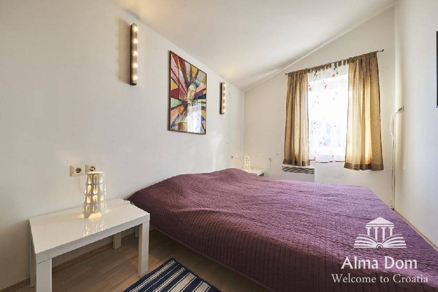 Helles Schlafzimmer mit Doppelbett, Nachttischen und dekorativer Beleuchtung.