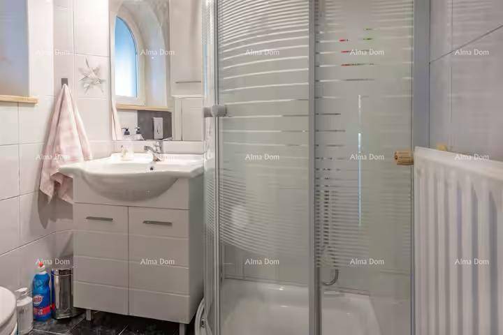 Badezimmer mit Duschkabine, Waschbecken, Spiegel und weißen Fliesen.