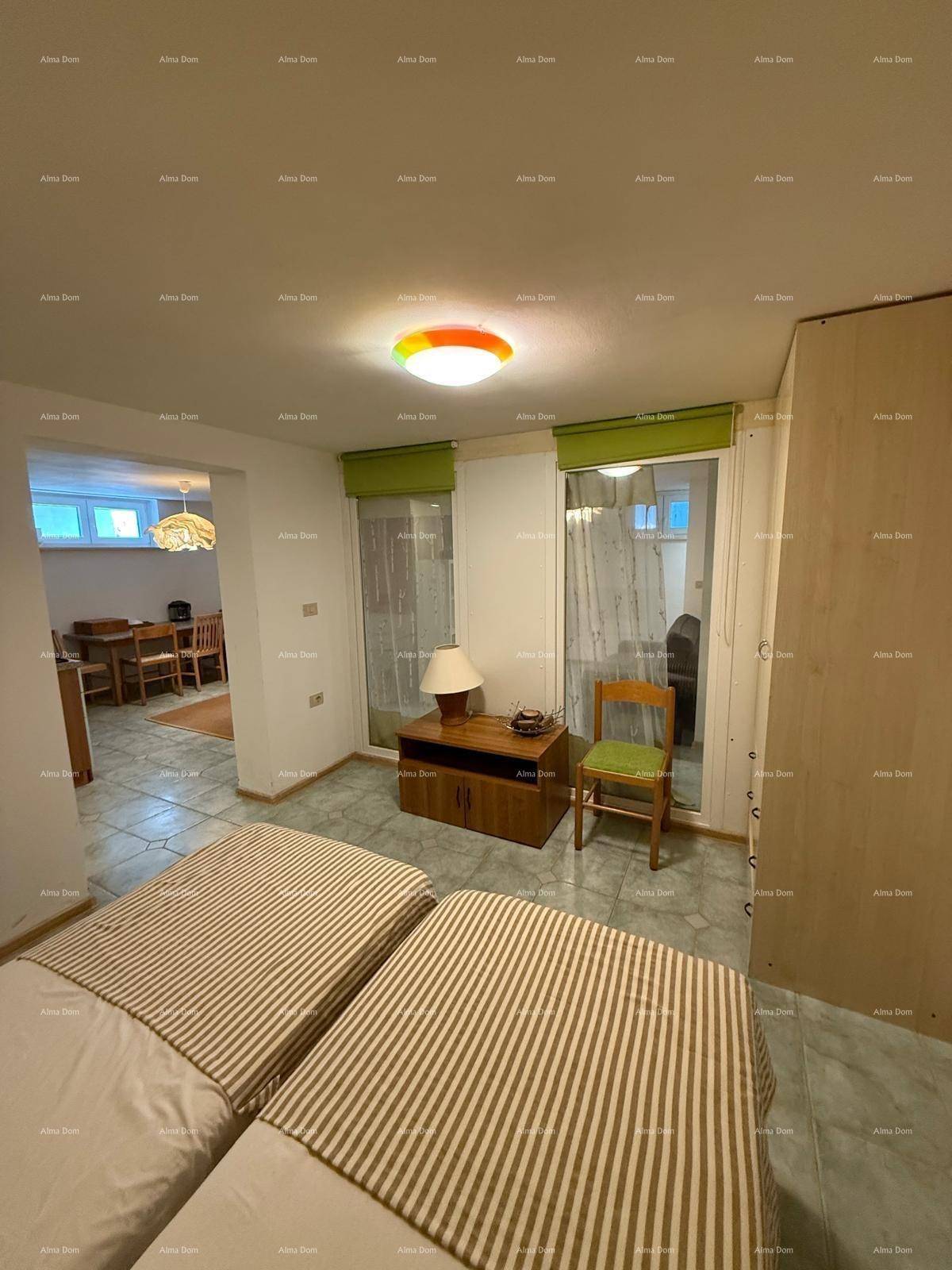 Schlafzimmer mit zwei Einzelbetten, Fliesenboden und Zugang zu einem weiteren Wohnbereich.