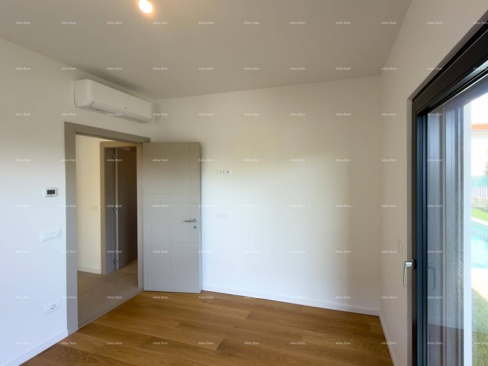 Helles Schlafzimmer mit Holzboden und Tür, die zu einem angrenzenden Bereich führt.