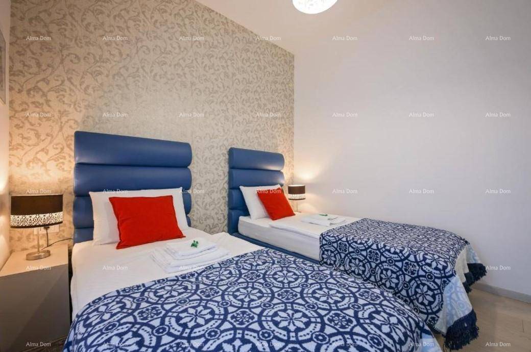 Schlafzimmer mit zwei Einzelbetten, blauen Kopfteilen und farbenfroher Bettwäsche in Blau und Rot.