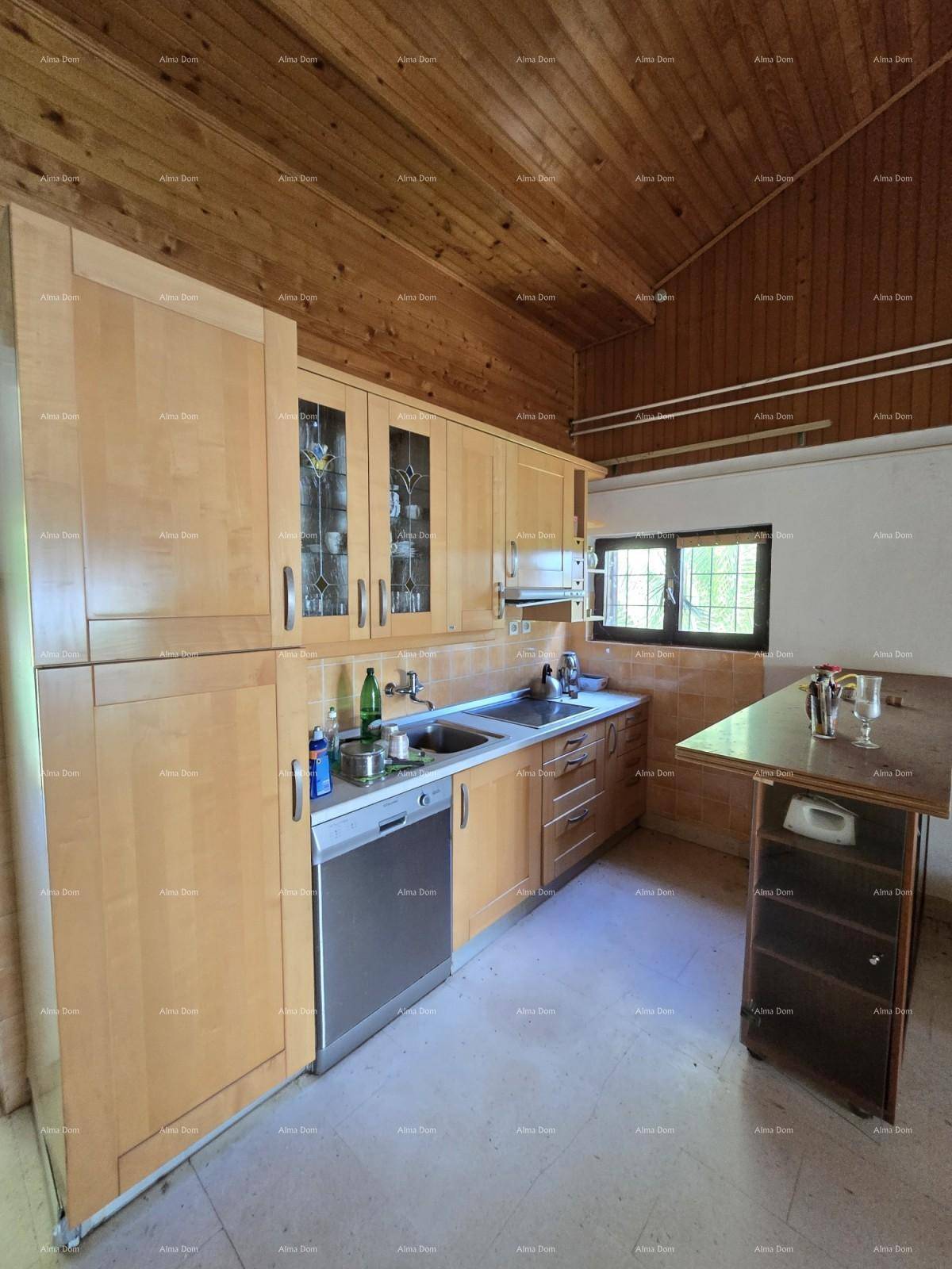 Funktionale Küche mit Holzschränken, Spülmaschine und Fenster, bietet ausreichend Arbeitsfläche.