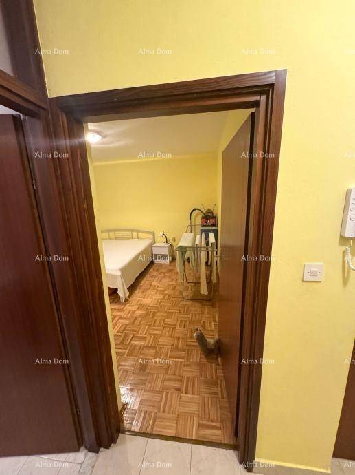Flur mit Zugang zu einem Schlafzimmer, das mit einem warmen Parkettboden ausgestattet ist.