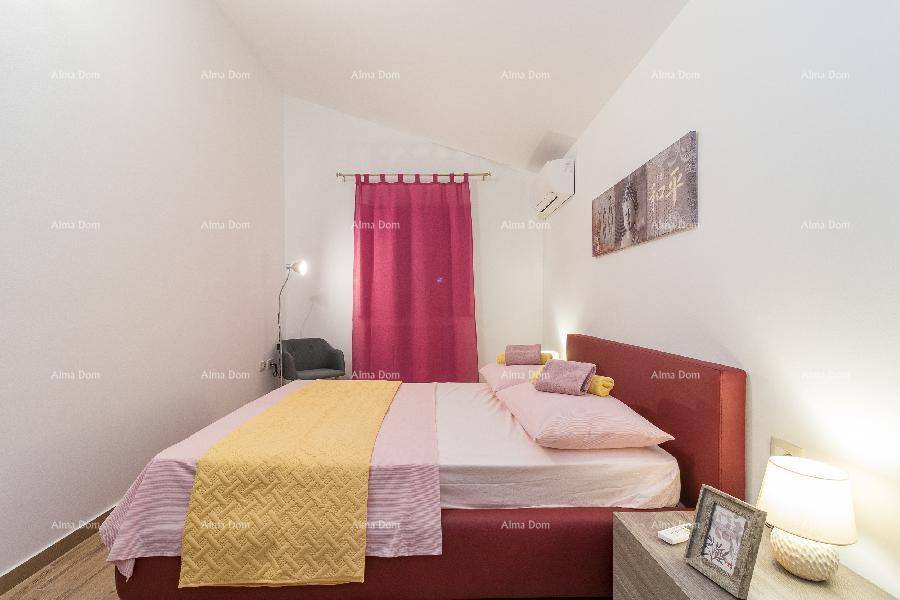 Gemütliches Schlafzimmer mit Doppelbett, pinker Bettwäsche und Klimaanlage für angenehme Temperaturen.