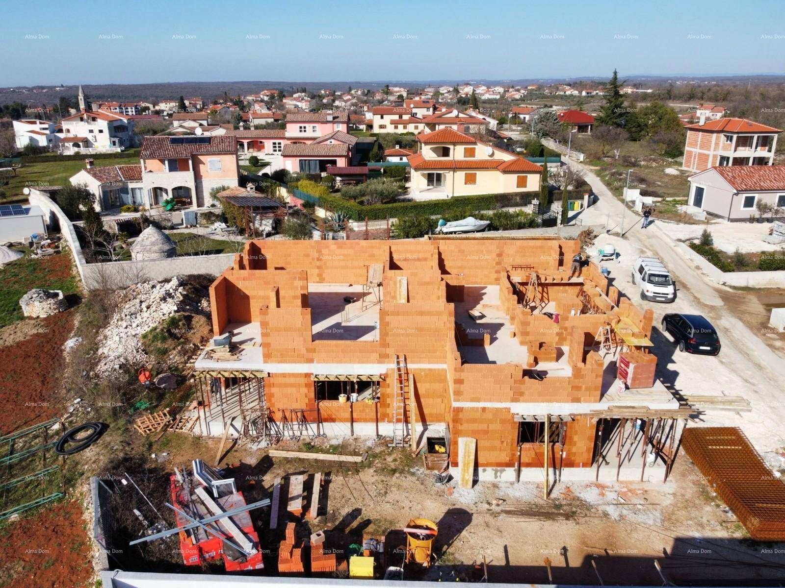Weitwinkel-Luftaufnahme einer Baustelle mit mehreren Rohbauten und der angrenzenden Wohnsiedlung.