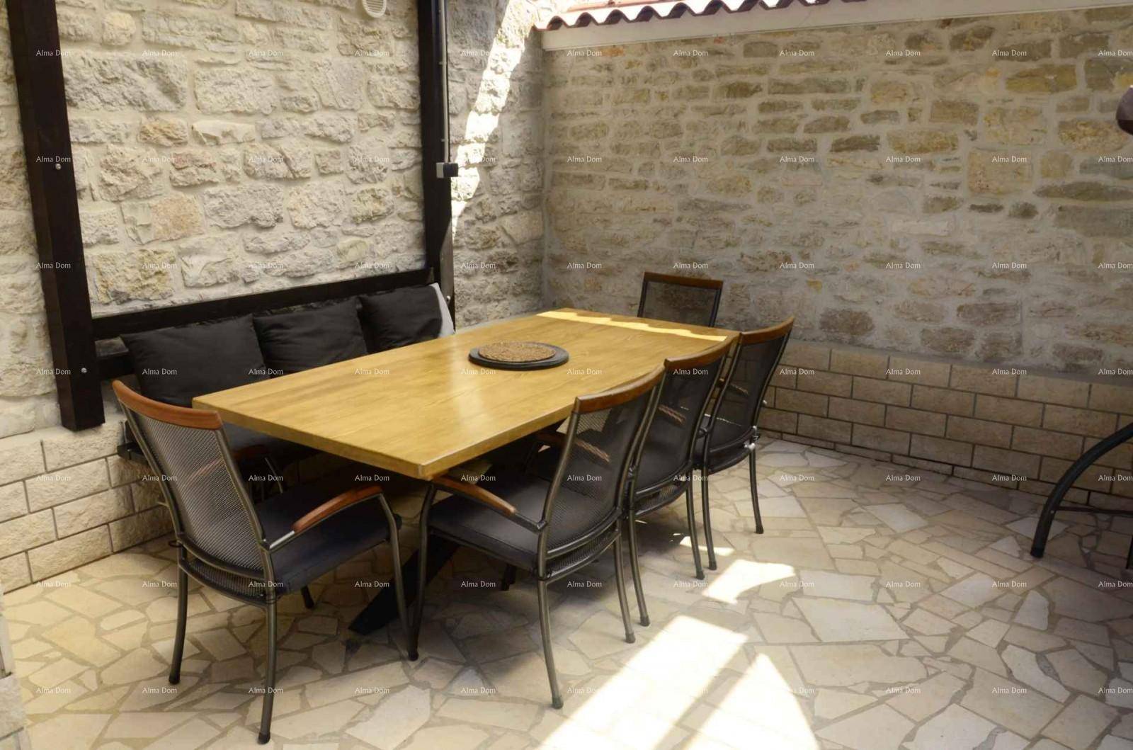 Gemütlicher Essbereich im Freien mit Holztisch und Steinwänden, ideal für Mahlzeiten im Schatten.