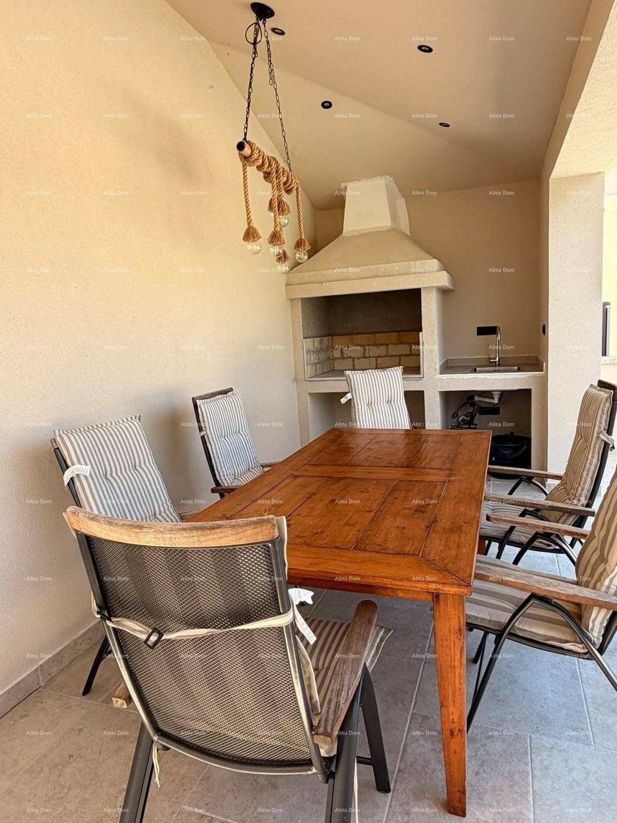 Überdachte Terrasse mit Essbereich und integriertem Grill für gesellige Abende.