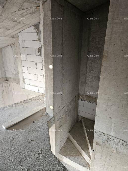 Treppenbereich im Rohbau mit Betonwänden und teilweise gemauerten Wänden, unfertige Betontreppe.