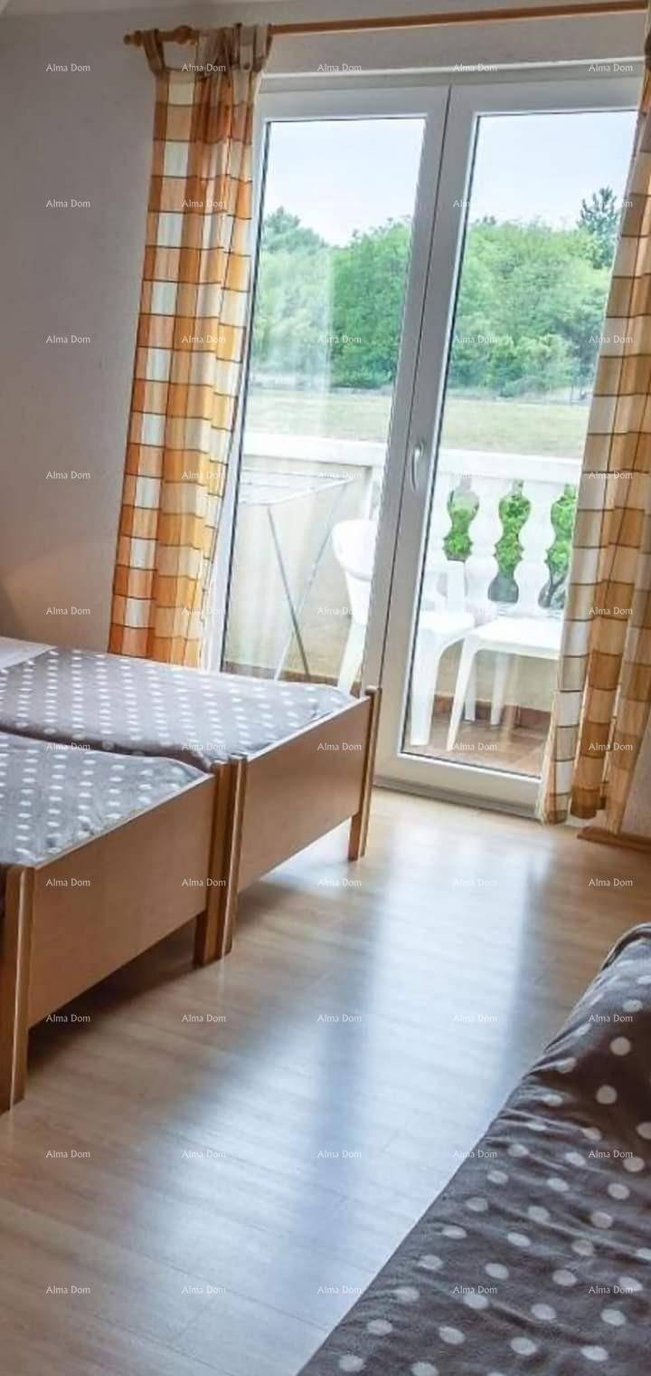 Schlafzimmer mit zwei Einzelbetten und Zugang zu einem Balkon mit Blick ins Grüne.