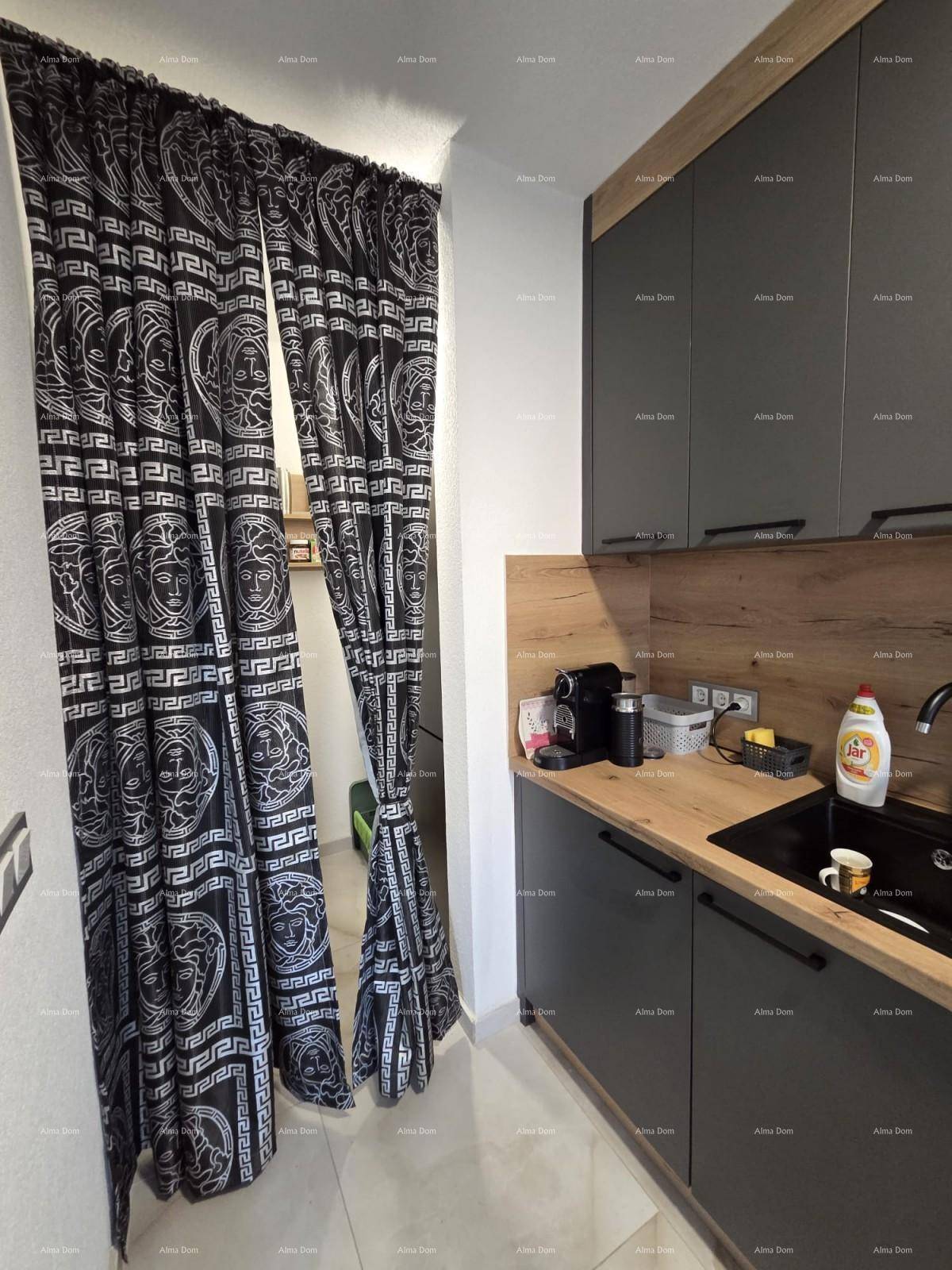 Moderne Küche mit dunklen Schränken, Holz-Arbeitsplatte und stilvollen Vorhängen.