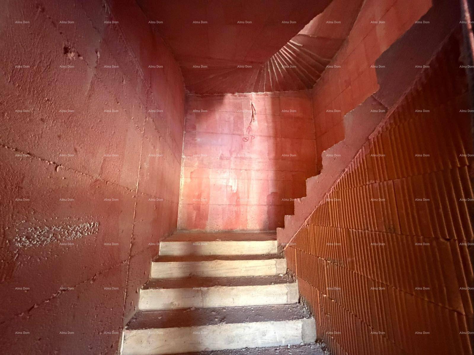 Treppenhaus im Rohbau mit unverputzten Ziegelwänden und Betonstufen.