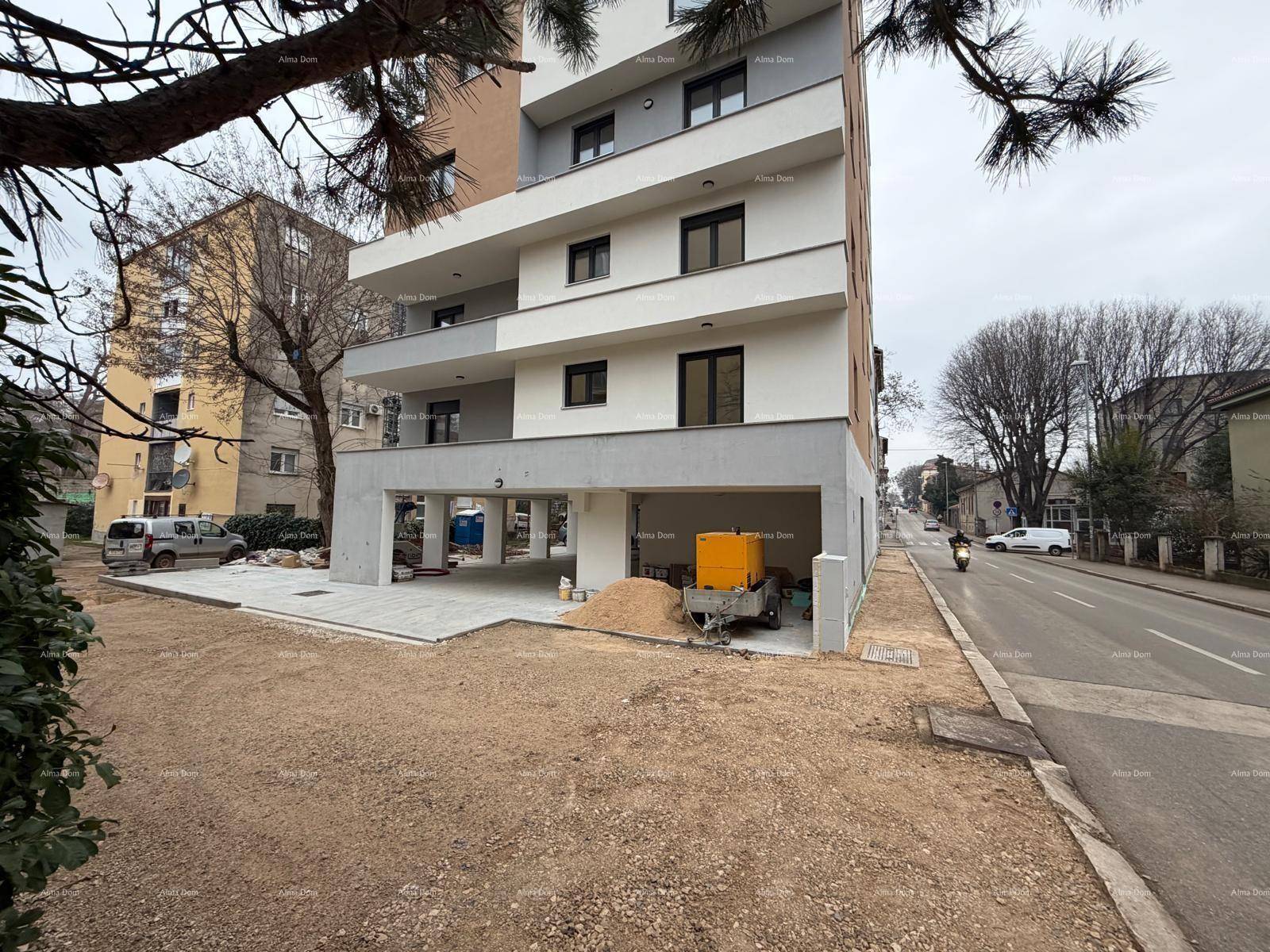 Nahaufnahme des modernen Mehrfamilienhauses im Bau mit offener Erdgeschosszone und Baustelle.