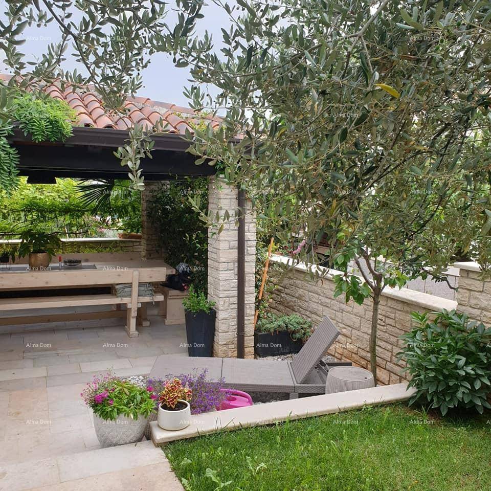 Mediterraner Gartenbereich mit Liegestuhl, Olivenbaum und Steinmauern, ideal zum Entspannen im Freien.