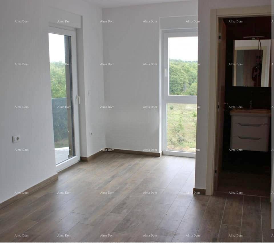 Helles Schlafzimmer mit Holzoptik-Fliesenboden und Zugang zu einem Badezimmer und Balkon.
