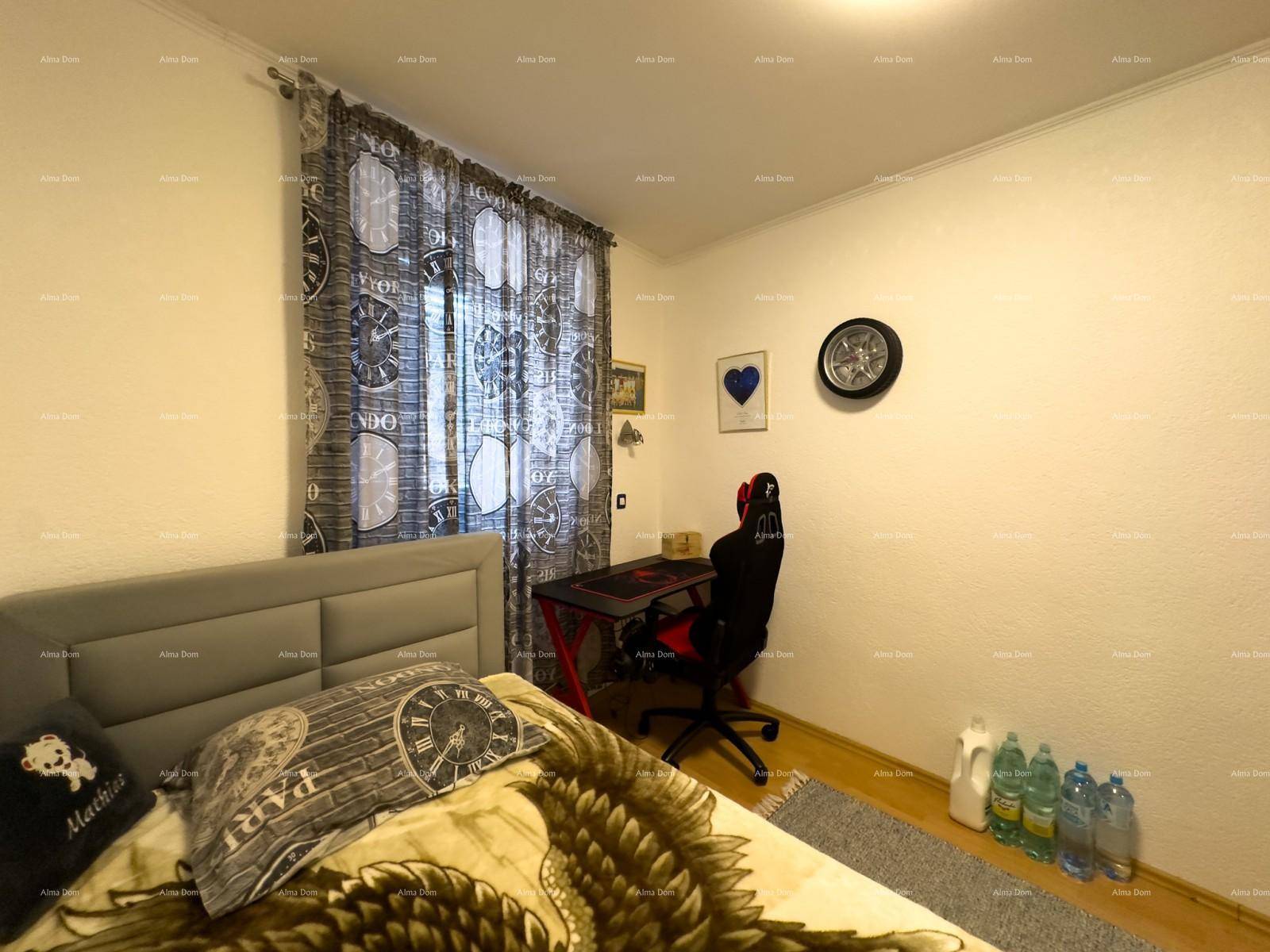 Helles Zimmer mit Einzelbett, Schreibtisch und Fenster mit Vorhängen.
