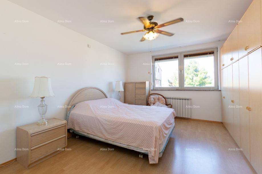 Helles Schlafzimmer mit Doppelbett, Einbauschränken und Deckenventilator.