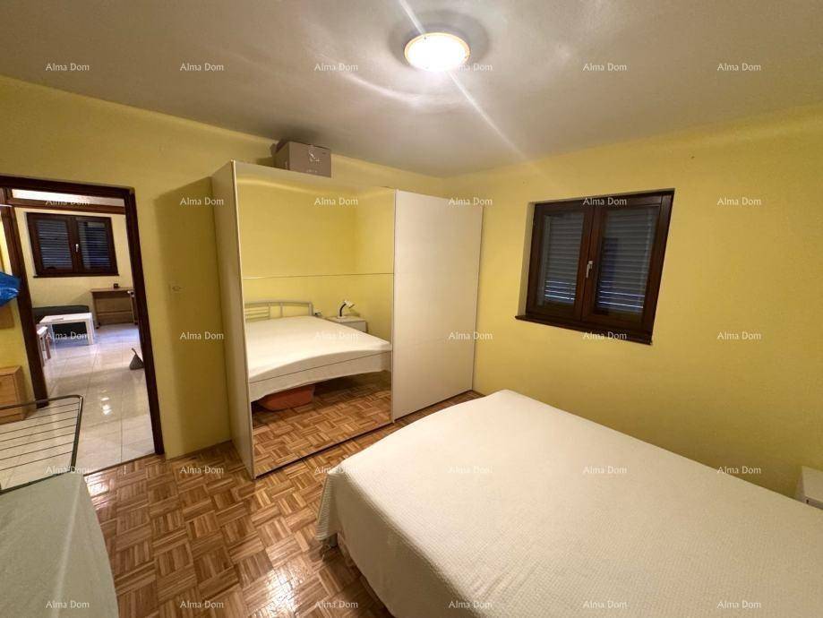 Schlafzimmer mit Parkettboden, Doppelbett und einem großen Spiegelschrank für Stauraum.