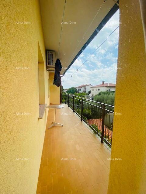 Langer Balkon mit Fliesenboden, Metallgeländer und Blick auf die Umgebung.