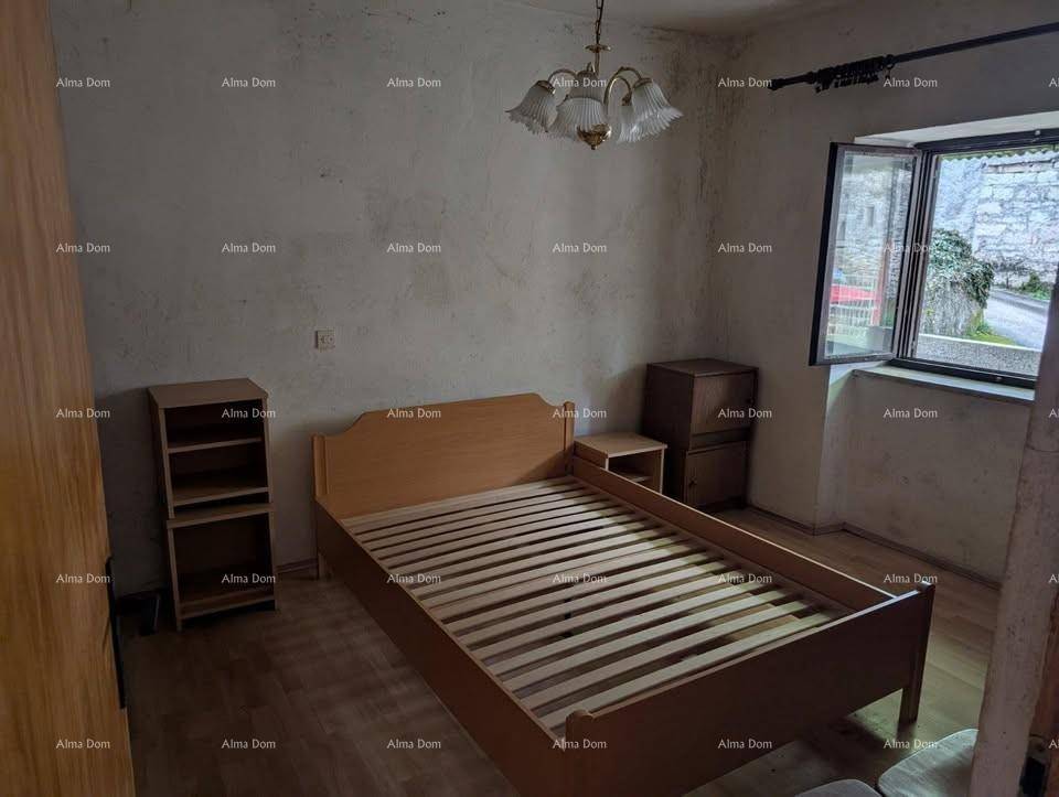 Schlafzimmer mit Holzbett und Nachttischen, Holzboden und einem Fenster mit Blick nach draußen.
