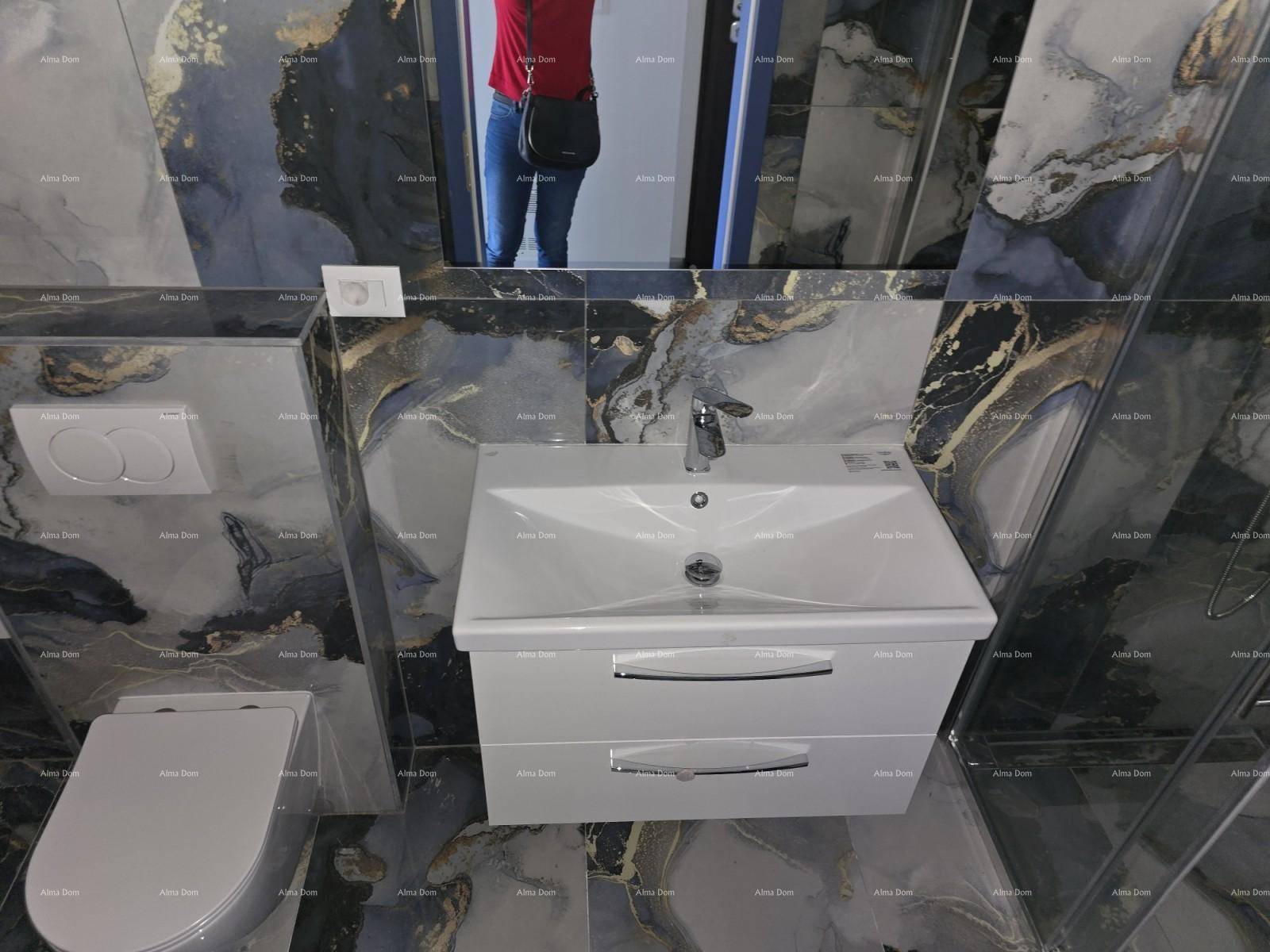 Modernes Badezimmer mit wandhängendem WC und Waschtisch, umgeben von dunklen Marmorfliesen und einem Spiegel.