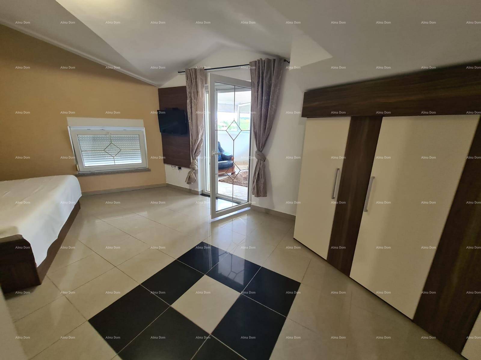 Schlafzimmer mit Fliesenboden, Schrank und Fenstern, die viel Tageslicht hereinlassen.