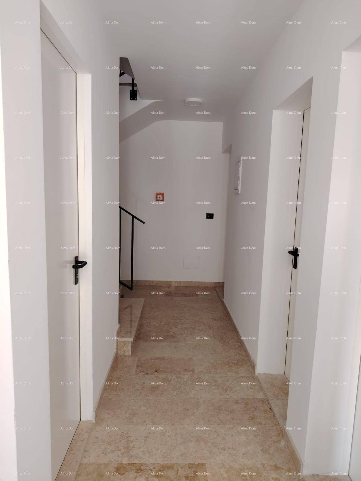 Heller Flur mit beigefarbenen Fliesen und weißen Türen, führt zu einem Treppenhaus.