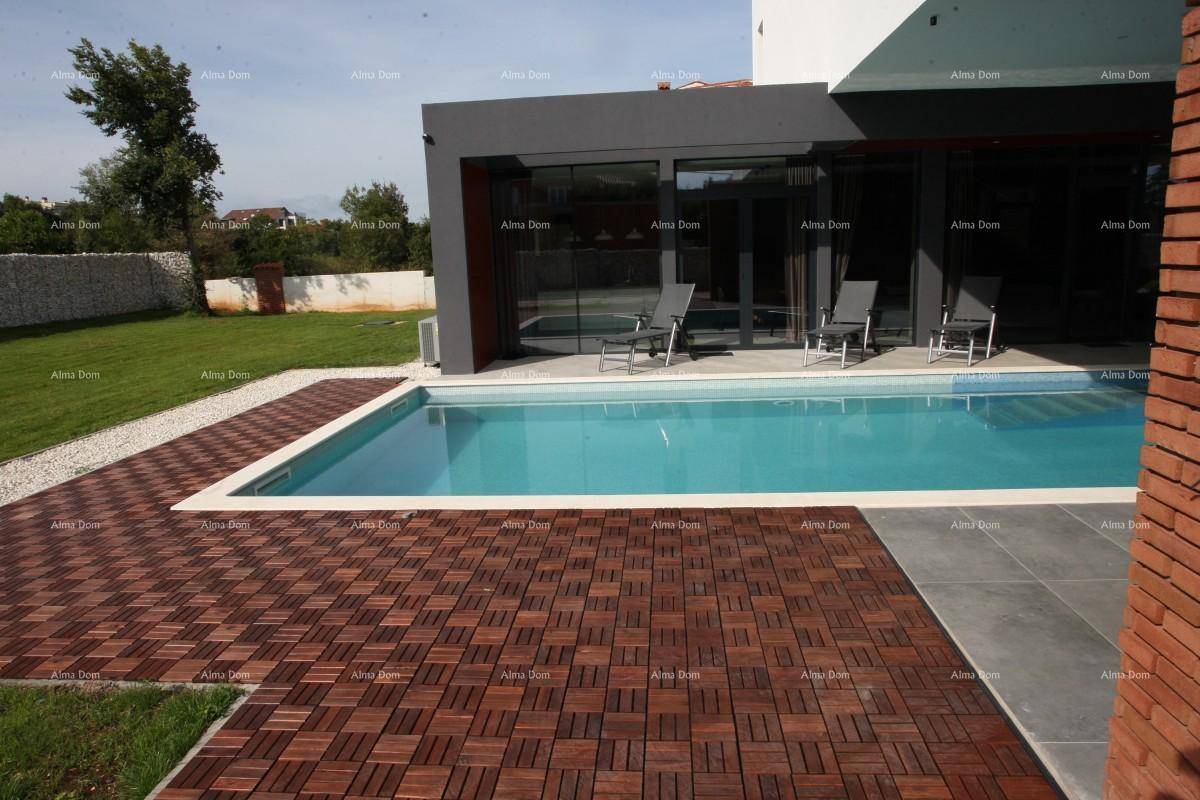 Außenbereich mit Pool, Holzterrasse und Rasenfläche, umgeben von einer Steinmauer.