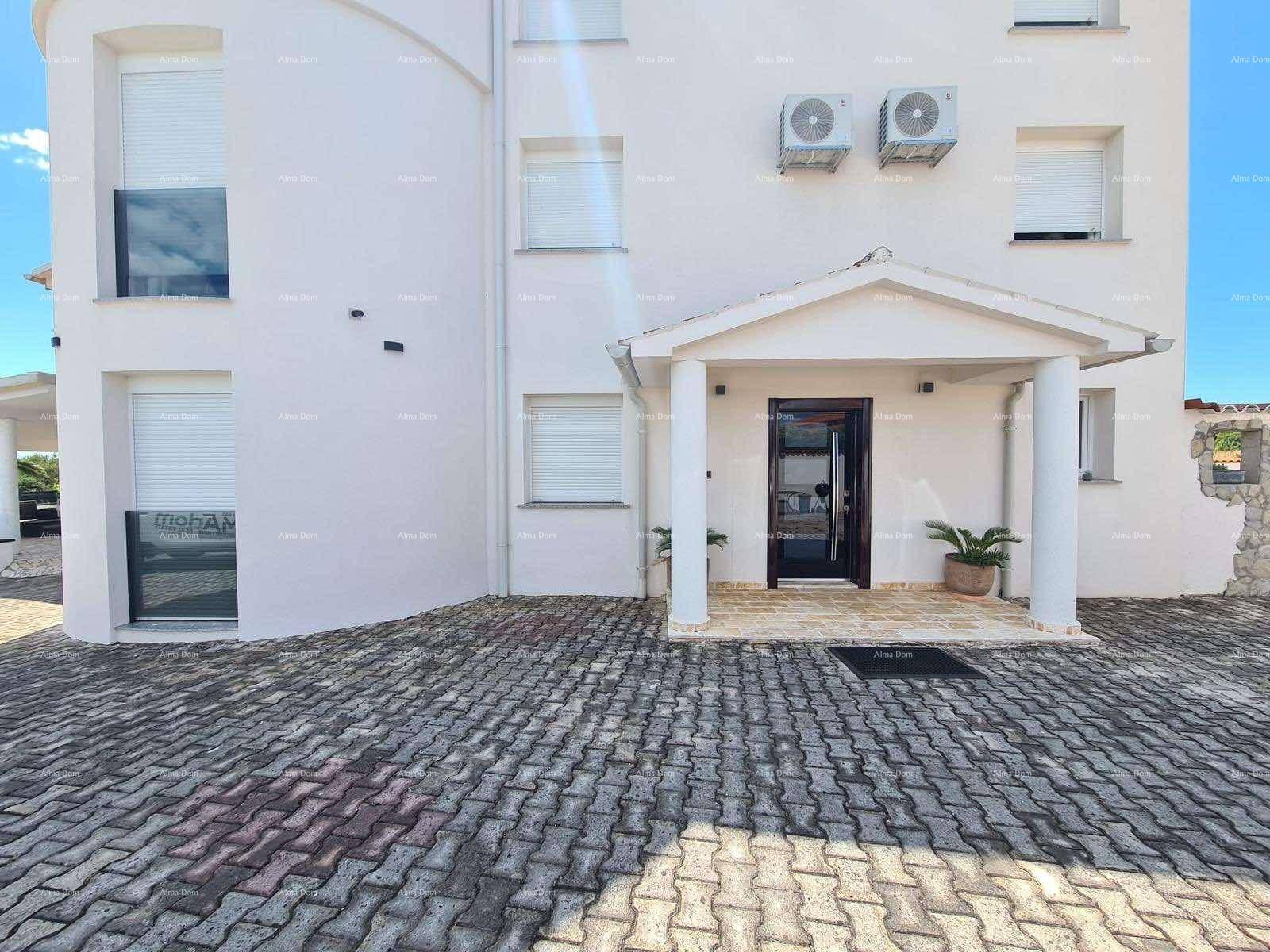 Haupteingang der modernen Villa mit überdachtem Portikus und gepflastertem Vorplatz.