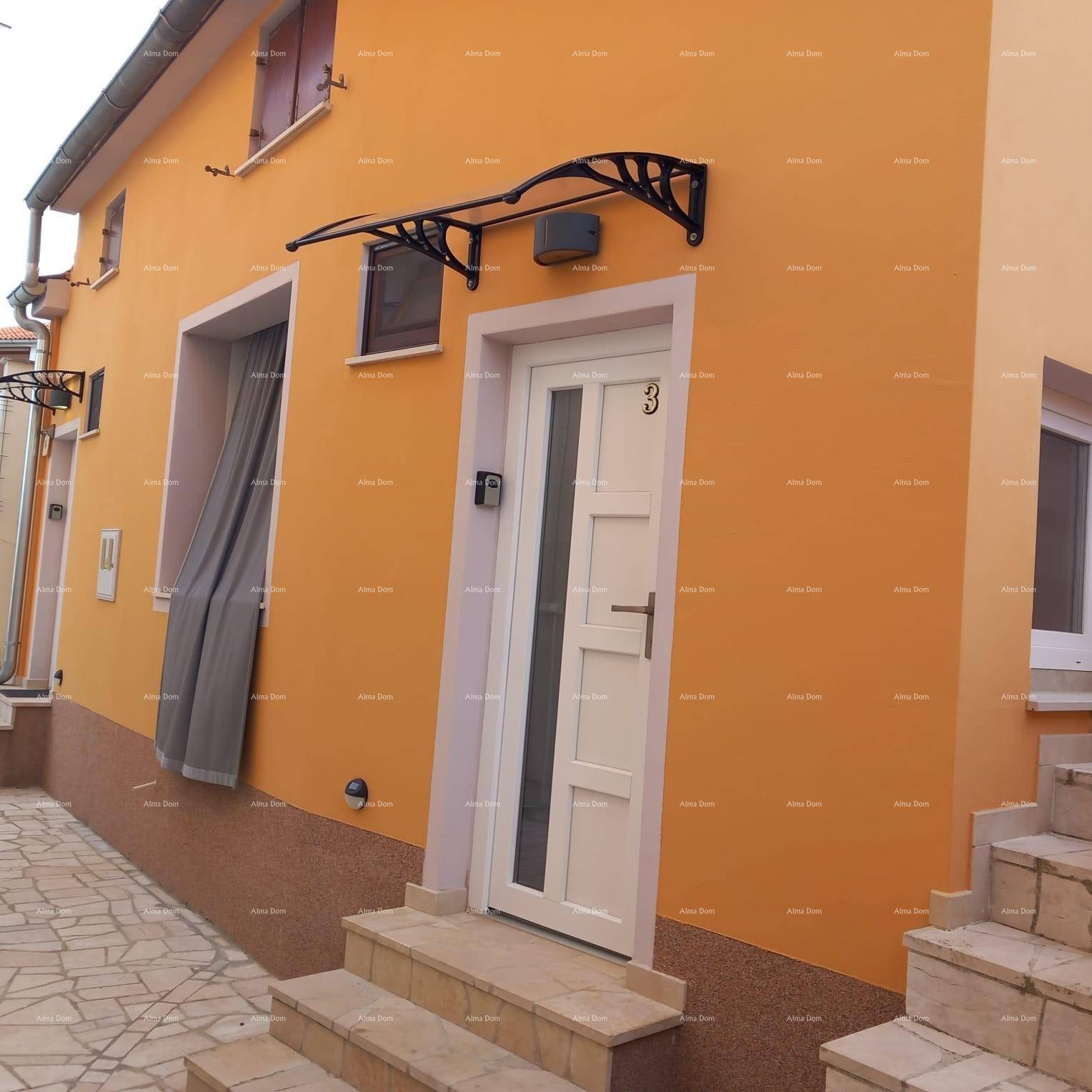 Eingangsbereich eines Hauses mit orangefarbener Fassade und weißer Tür.