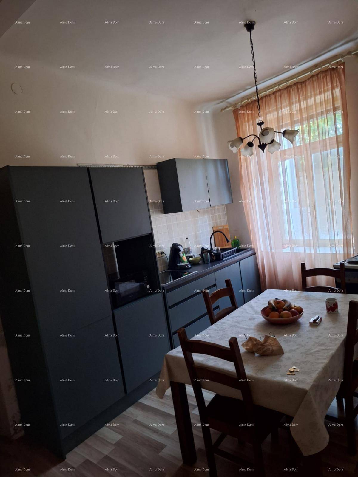 Moderne Küche mit dunklen Schränken, Esstisch und Fenster.