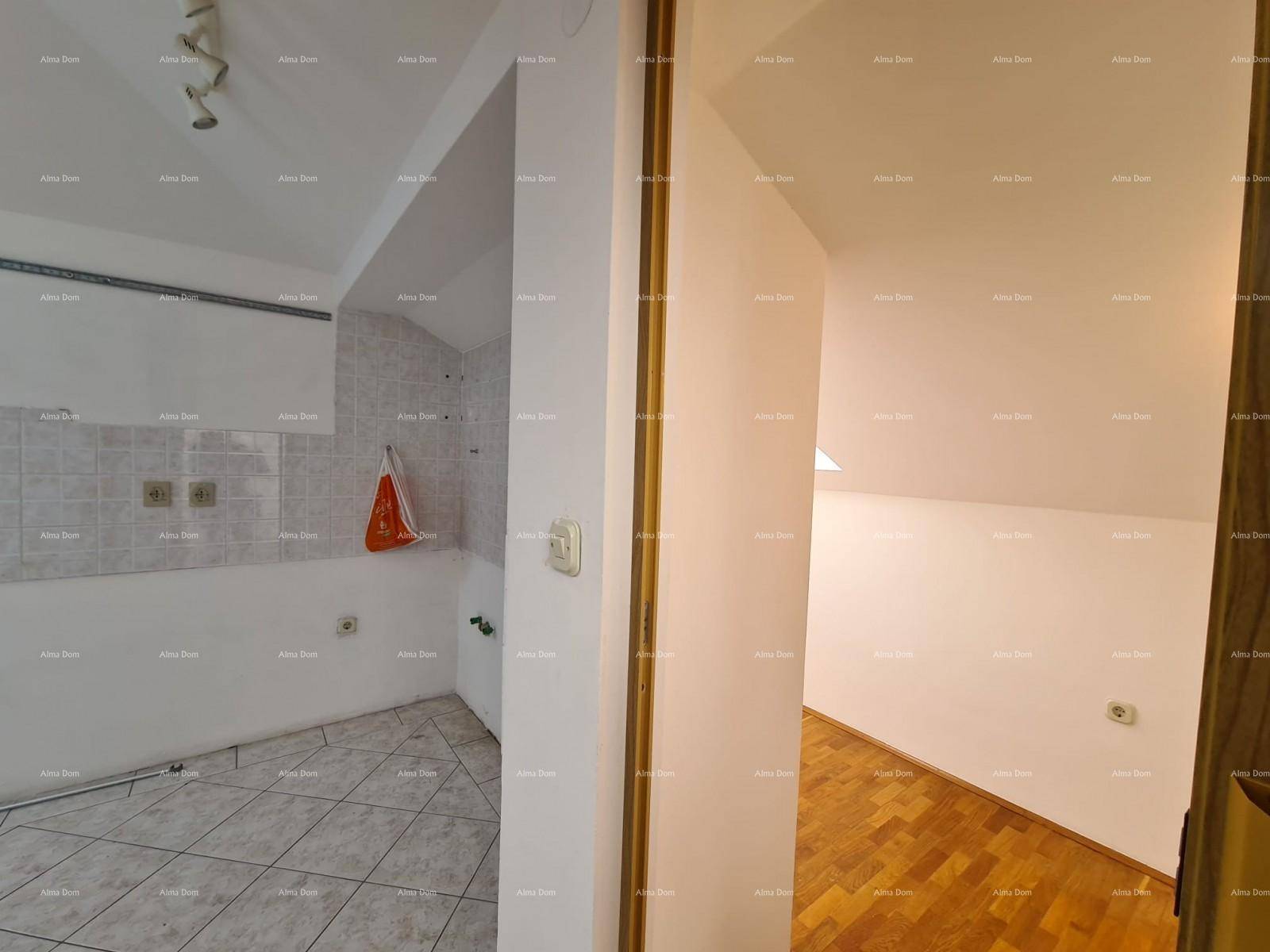 Flur, der einen unfertigen Küchenbereich mit einem hellen Zimmer mit Holzparkettboden verbindet.