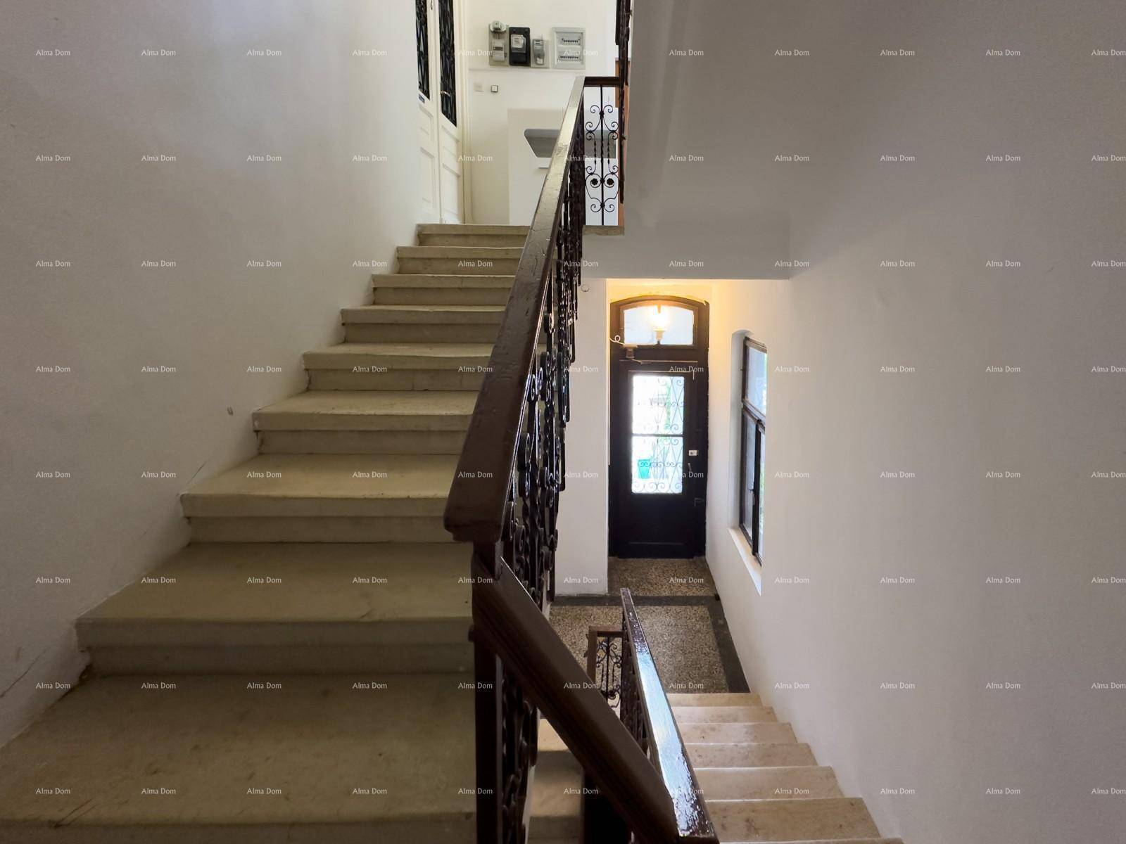 Geräumiges Treppenhaus mit elegantem schmiedeeisernem Geländer, das zum Eingangsbereich führt.