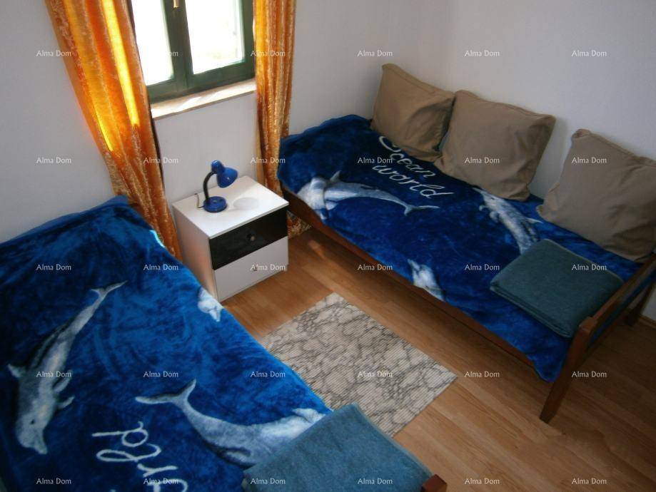 Helles Schlafzimmer mit zwei Einzelbetten, Holzboden und Fenster.