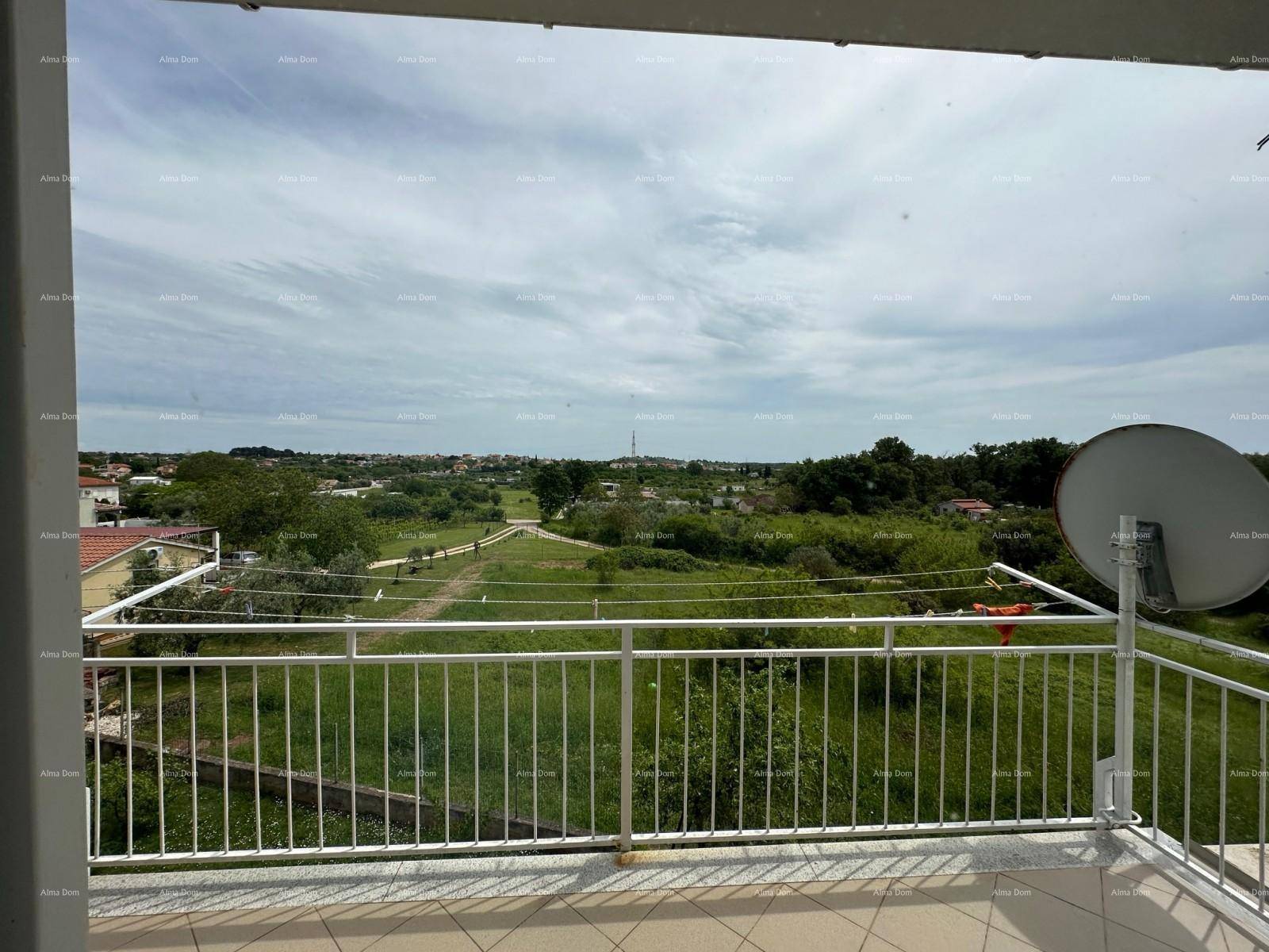 Balkon mit weitem Blick über grüne Landschaft und entfernte Siedlungen.