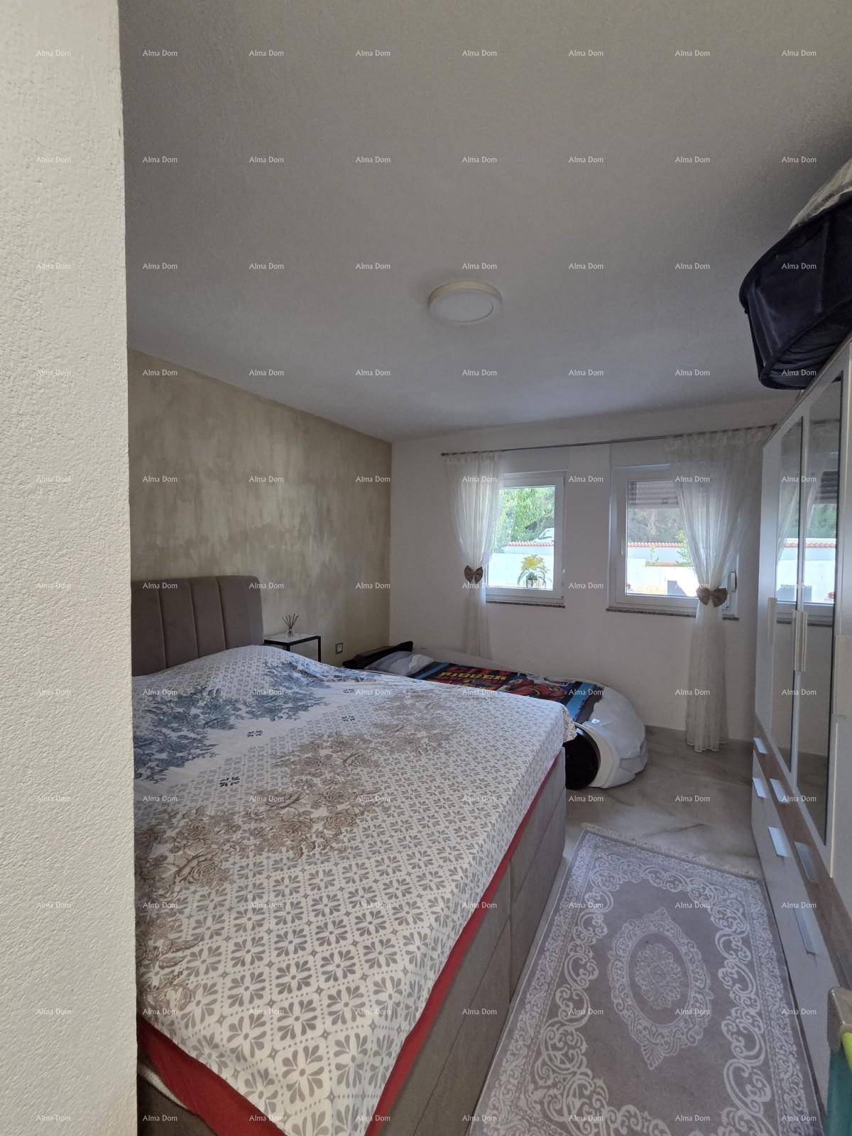 Helles Schlafzimmer mit Doppelbett, Kleiderschrank und zwei Fenstern für viel Tageslicht.